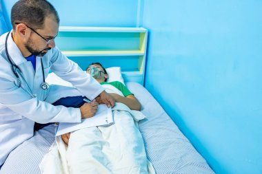 Doktor hastasını kontrol ediyor ve sonuçlarını yazıyor.