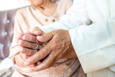 İki yaşlı insan el ele tutuşuyor.