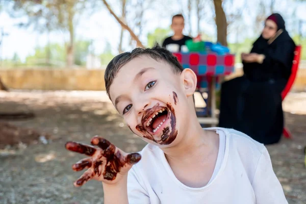 Mutlu küçük çocuk ellerini çikolatayla kaplamaktan zevk alıyor.