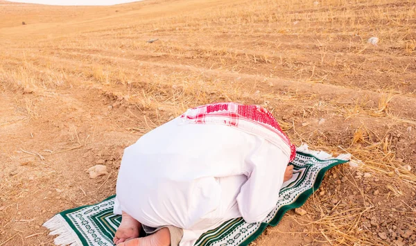 Arab people outside praying for god in the nature