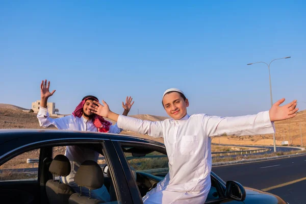 happy arabic family outside the car window waving at each other