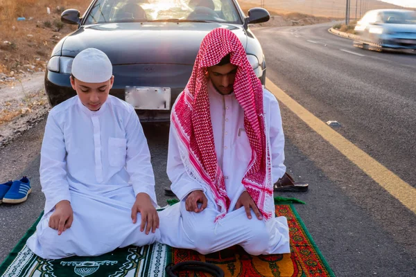 Arab people outside praying for god in the nature