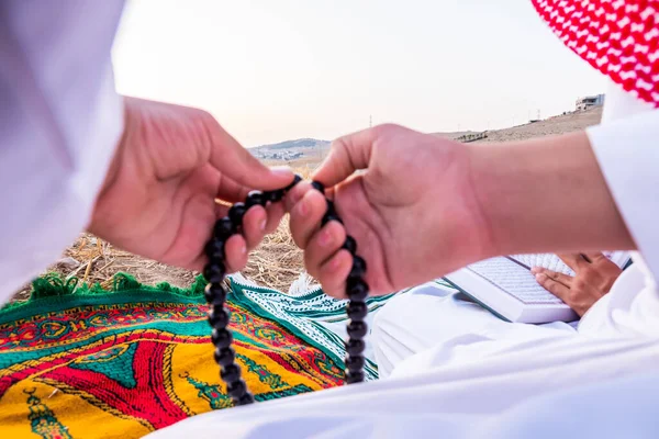 Arab people outside praying for god in the nature