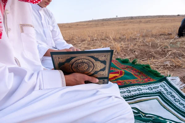 Arab people outside praying for god in the nature