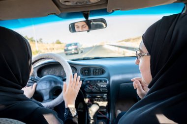 İki Arap kadın tartışırken araba kullanıyor