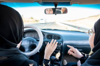 İki Arap kadın tartışırken araba kullanıyor