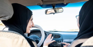 İki Arap kadın tartışırken araba kullanıyor