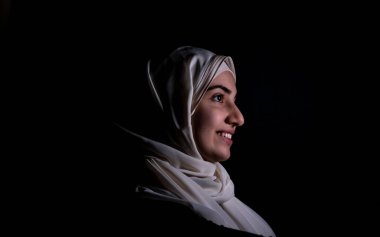 Karanlık bir odada bir araya gelen Orta Doğulu erkeklerin portresi.