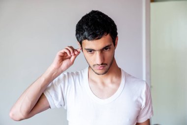 Müslüman adam kulağını temizliyor.