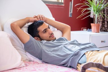 Muslim man having a nap in the bed room clipart