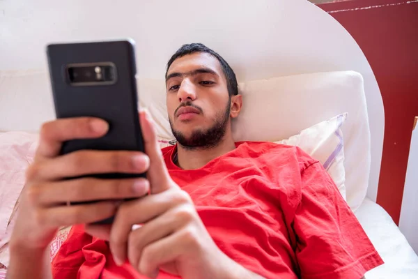 Menino Muçulmano Deitado Cama Olhando Para Telefone — Fotografia de Stock