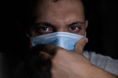 Karanlıktaki adam nefesini emisyon kirliliği ve hastalıklardan koruyor.