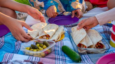Aile elleri yerde halısı olan bir kum cadısını yiyor.