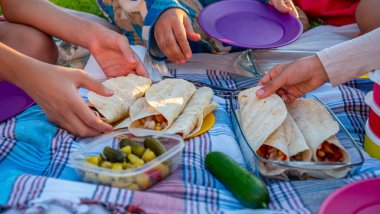 Aile elleri yerde halısı olan bir kum cadısını yiyor.