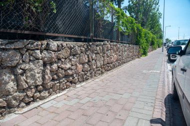 Modern tasarımda bazı park halindeki arabaların yanında insanlar için kaldırım