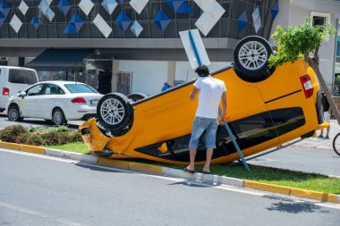 Kötü koşullarda sokakta takla atan bir arabanın portresi.