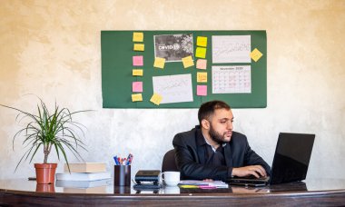 Evden ofisinde çalışan bir adamın portresi.