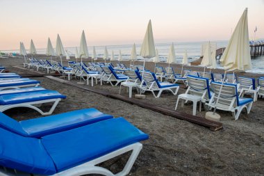 Deniz kenarındaki kumlu sahilde sandalyeler