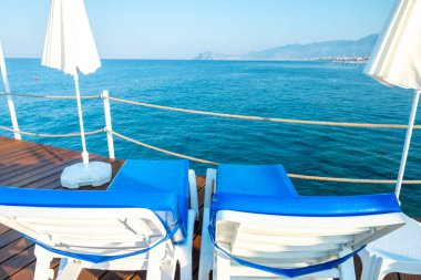 Üzerinde banklar olan iskele beyaz denizde yaz tatiline hazır.