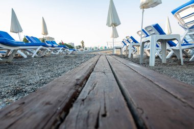 Deniz kenarındaki kumlu sahilde sandalyeler