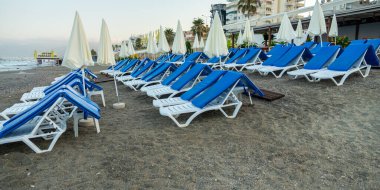 Deniz kenarındaki kumlu sahilde sandalyeler