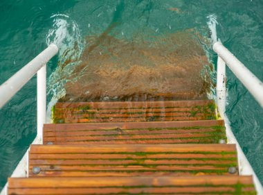 İskeledeki eski ahşap merdivenler ve güzel bir su.