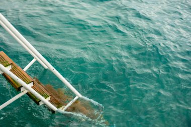 İskeledeki eski ahşap merdivenler ve güzel bir su.