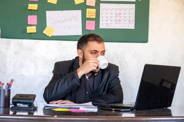 Uomo Che Beve Mentre Lavora Nel Suo Ufficio — Foto Stock