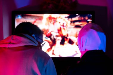 Müslüman arkadaşlar konsolda birlikte oynuyorlar.