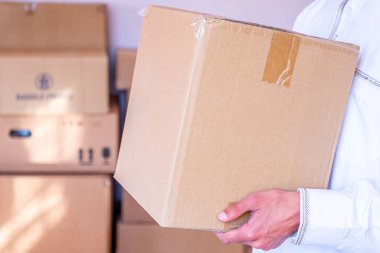 Arap adam elinde karikatür kutusu tutuyor.