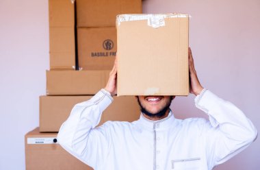 Arap adam kafasına karton kutu koyuyor.