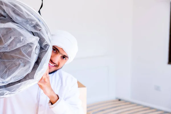 アラビア系イスラム教徒の男性が包み紙のマットレスを持ち ストック画像