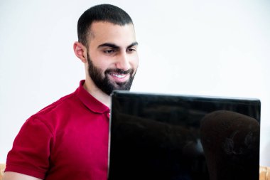 Konferanslarda veya toplantılarda online kanallar aracılığıyla eğitim ve öğretim için dizüstü bilgisayar kullanan Arap bir adam