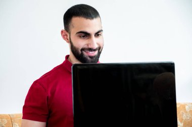 Konferanslarda veya toplantılarda online kanallar aracılığıyla eğitim ve öğretim için dizüstü bilgisayar kullanan Arap bir adam