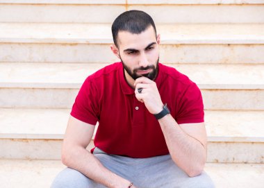 Adam merdivenlerde oturup düşünüyor.