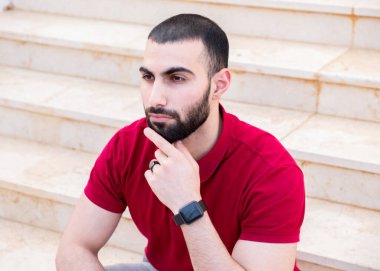 Adam merdivenlerde oturup düşünüyor.