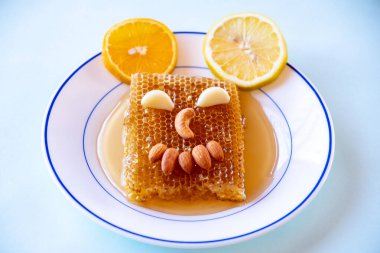 Bal kovanından, bademlerden ve portakallı ve limonlu bir tabakta hurma ile doldurulmuş bayram kahklarından yapılmış gülen yüz.