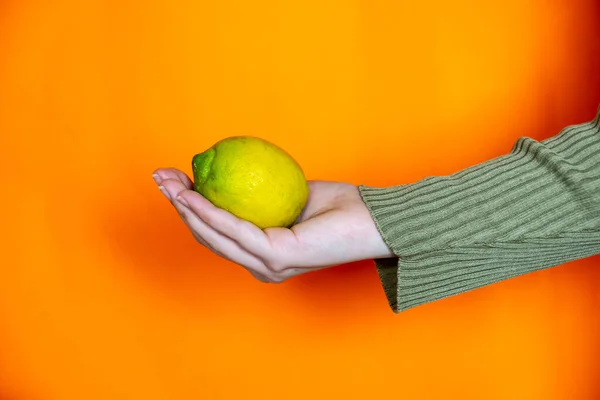 Händer Som Håller Citron Med Orange Bakgrund Royaltyfria Stockbilder