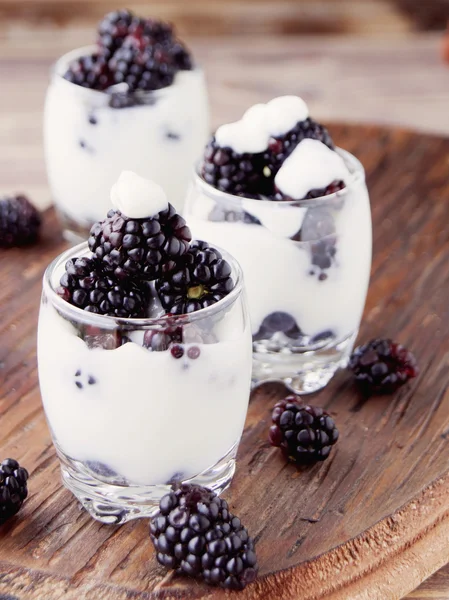 yogurt cup with blackberry on wooden table