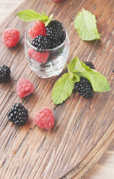 Baies noires et framboises dans une tasse en verre — Photo