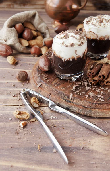 Chocolate quente em copos de vidro e creme com nozes — Fotografia de Stock