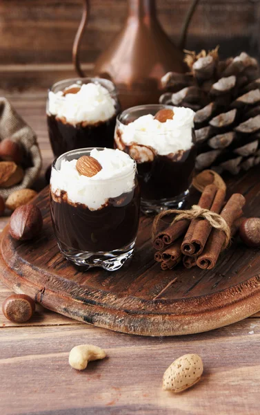 Chocolate quente em copos de vidro e creme com nozes — Fotografia de Stock