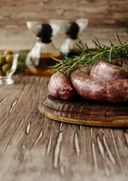 Surowej wołowiny kiełbaski na patelni żeliwnych, selektywne focus — Zdjęcie stockowe
