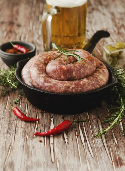 Salsichas de carne crua em uma panela de ferro fundido, foco seletivo — Fotografia de Stock