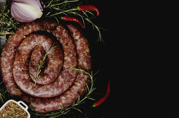 Salsichas de carne crua em uma panela de ferro fundido, foco seletivo — Fotografia de Stock