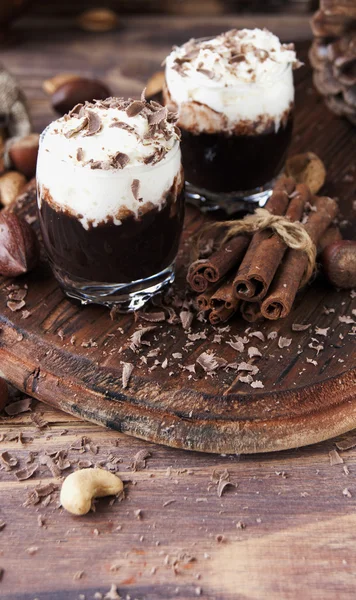 Chocolate caliente en tazas de vidrio y crema con nueces —  Fotos de Stock