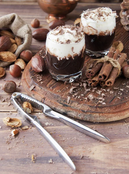 Chocolate caliente en tazas de vidrio y crema con nueces —  Fotos de Stock