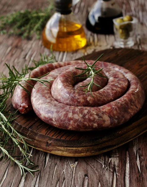 Salsichas de carne crua em uma panela de ferro fundido, foco seletivo — Fotografia de Stock