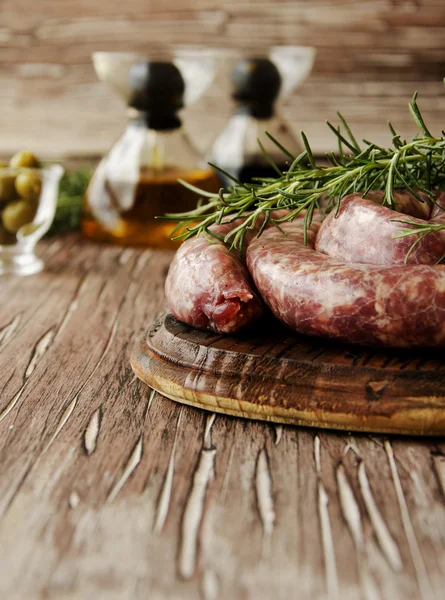 Surowej wołowiny kiełbaski na patelni żeliwnych, selektywne focus — Zdjęcie stockowe
