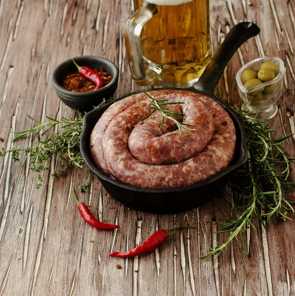 Salsichas de carne crua em uma panela de ferro fundido, foco seletivo — Fotografia de Stock